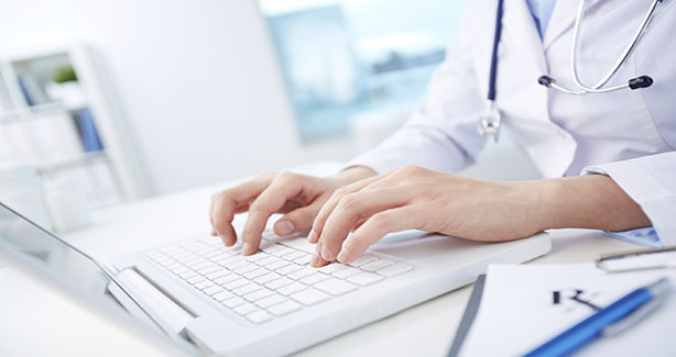 Health care provider typing into keyboard 